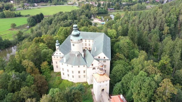 Aerial view of Lemberg Castle surrounded by dense forests and lush greenery in Jablonne v Podjestedi, Liberecky kraj, Czechia.