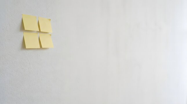 Four yellow sticky notes arranged in a square on a clean white office wall background
