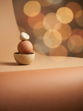 Balanced ceramic bowl egg stone and rounded rock against warm bokeh lights