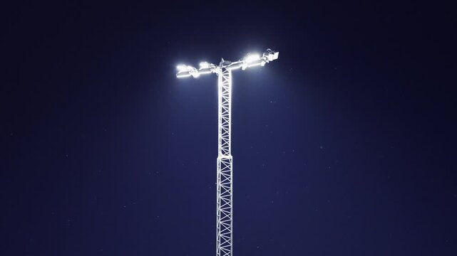 Stadium floodlight tower against a dark blue evening sky