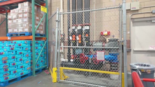 Langford, BC, Canada - Aug 11, 2026: Commercial warehouse fire riser system behind chain link security fence