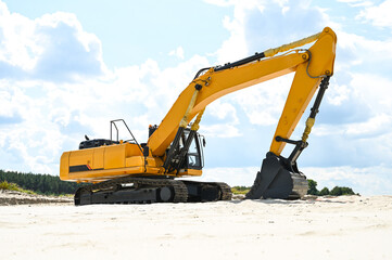 Excavator working in a sandy quarry, digging and moving sand. Industrial construction scene showing heavy machinery operating at a sand extraction site. © senssnow