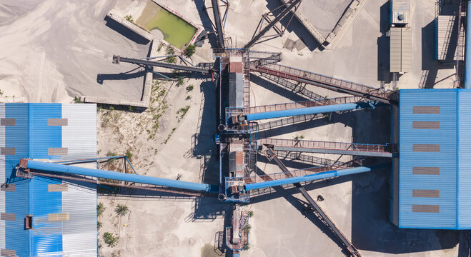 Aerial view of an extensive conveyor belt system transporting and distributing crushed stone at an industrial aggregate processing facility in Valence, Auvergne-Rhone-Alpes, France.