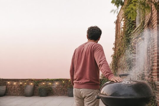 Outdoor barbecue grilling on a rooftop terrace at sunset