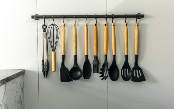 Jogo de utens&iacute;lios para cozinha, pendurados na parede, tais como conchas, colheres, garfos e pegadores