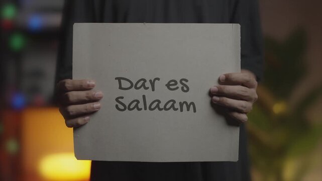 Dar es Salaam Written on Banner &ndash; Man Holding Placard