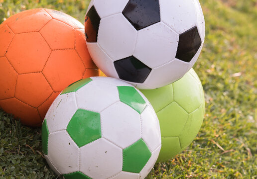 Three Soccer Balls on Green Grass Outdoors