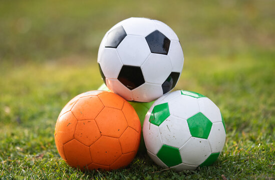 Three Soccer Balls on Green Grass Outdoors