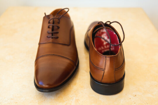 Pair of new brown leather men dress shoes neatly arranged a clean surface.