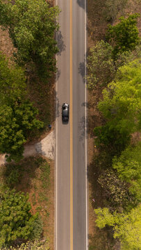 Aerial video of a rural road near a mountain with morning mist in Thailand.	