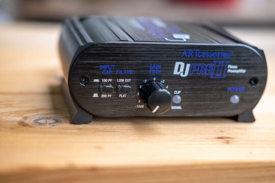 Black phono preamplifier with RCA connectors, ground terminal, power input jack, close-up view, High-fidelity audio equipment, Quality Essential gear for audiophiles, analog device for turntable
