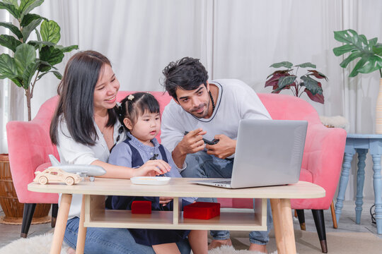 Happy family spending quality time together at home with parents' children enjoying fun and relaxed moment around a table.