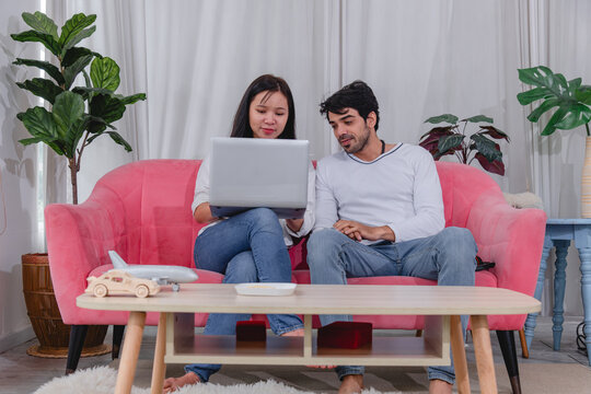 Happy husband and wife relaxing together at home while using tablet and enjoying quality time comfortable sofa.