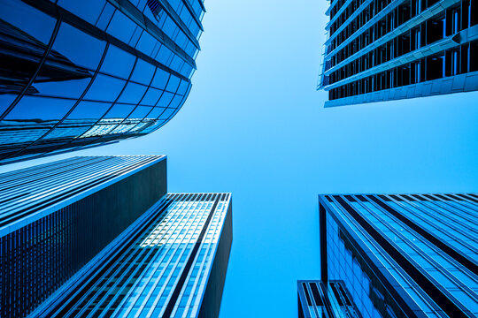 Open sky fills the frame in London's financial district, while a vertical perspective follows glass upward as office architecture closes around a skyscraper facade.