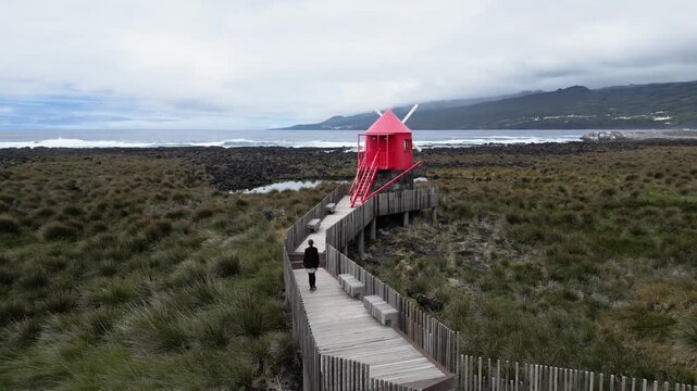 Drone View of Woman Walking Toward Juncal Mill in Lajes do Pico on Pico Island, Azores, Portugal