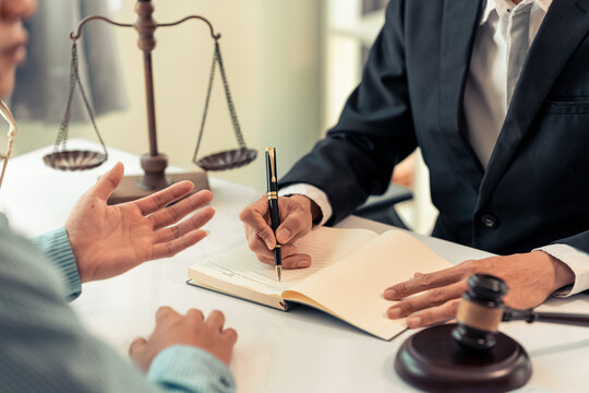 Lawyer and Client Signing Legal Contract Agreement Document in Law Office