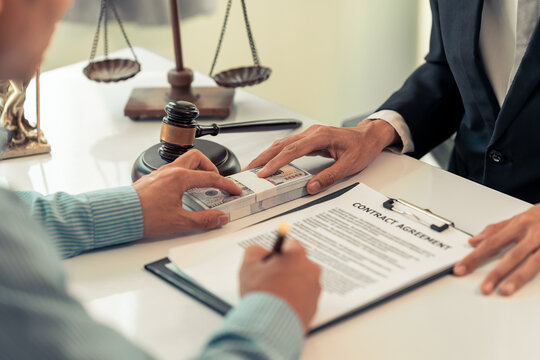 Lawyer and Client Signing Legal Contract Agreement Document in Law Office