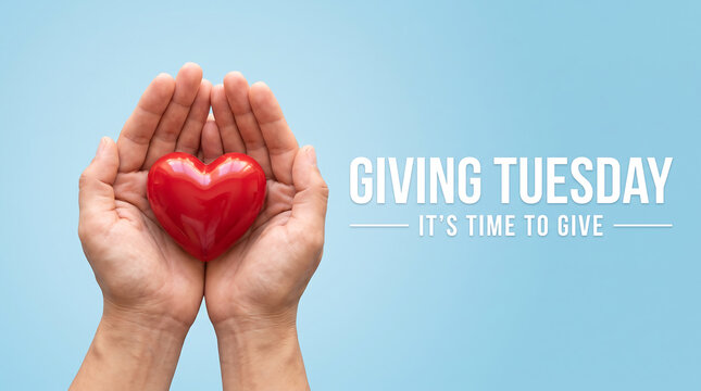 Heart shape held in two cupped human hands representing charity and kindness on blue background surface