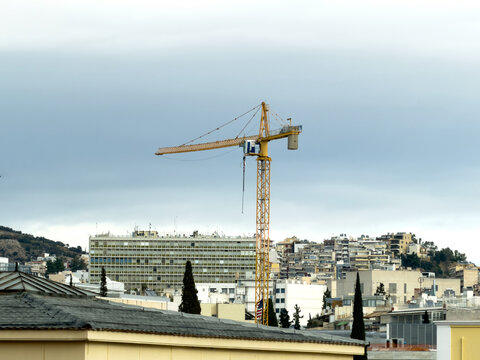 Construction tower crane above hillside apartments in Kolonaki, Athens, Greece