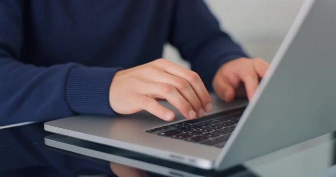 Close up of person hands typing on laptop keyboard for remote work or online business project.