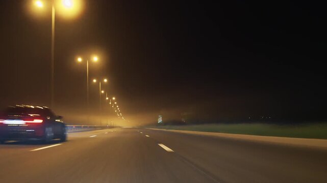 Car driving on night highway with street lights