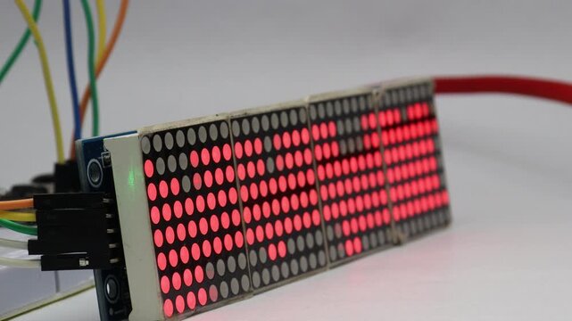 Glowing red dots move steadily across this LED matrix display showing the concept of data transmission and digital signal flow