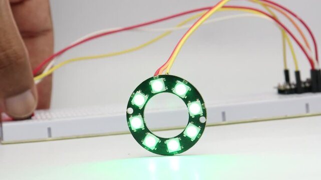 Placing a finger on touch sensor module on the breadboard circuit triggers an RGB LED ring to light up
