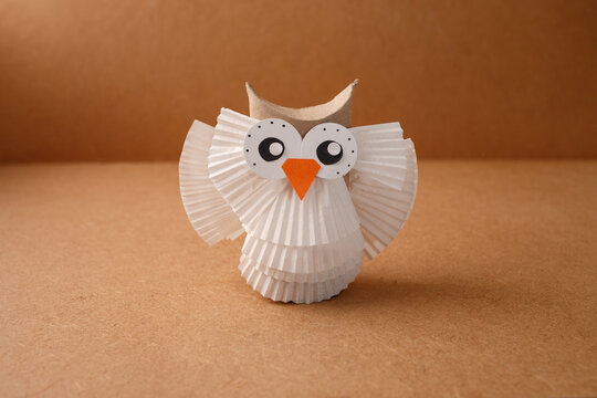 Creative cardboard owl figurine for children workshop, art class, preschool curriculum, educational blog, stationery shop promotion on brown background