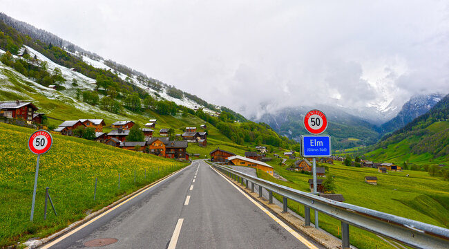 Malerische Ortseinfahrt im Alpendorf Elm im Kanton Glarus bei bew&ouml;lktem Wetter