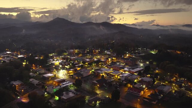 Franklin main street lined with illuminated restaurants, souvenir stores, and mountain lodges. North Carolina travel destination at night.
