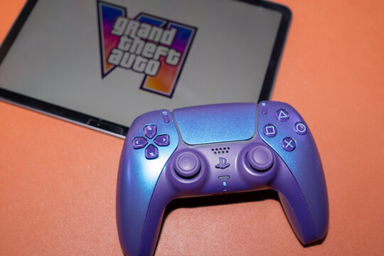 YEREVAN, ARMENIA - 08.11.2026: Sony PlayStation 5 DualSense controller next to a tablet displaying the official Grand Theft Auto VI GTA 6 artwork and logo