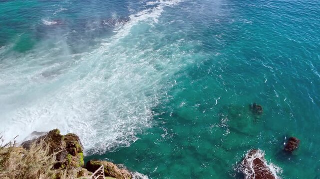 Aerial view of duden waterfall cascading over cliffside rocks directly into turquoise mediterranean sea.