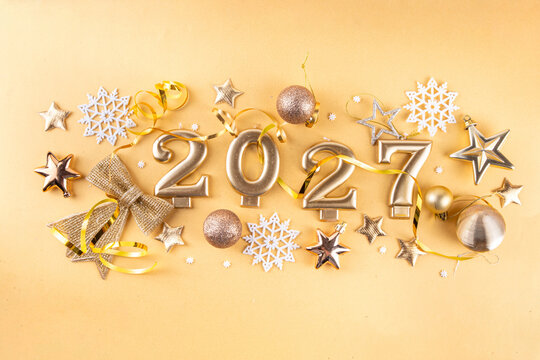 Merry Christmas Happy New Year 2027 background, New year 2027 celebration greeting card, Numbers candles 2027 with golden party decoration on gold background. Christmas, Noel New Year holidays banner