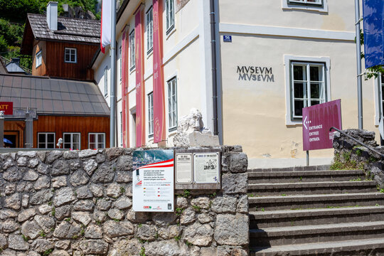 Entrance to Hallstatt Museum with Stone Stairs, Information Signs, and Flags in Austria. Hallstatt, Austria - June 22, 2026