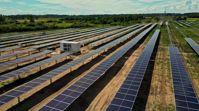 Aerial view of rows of photovoltaic solar panels installed in a field in Latvia.