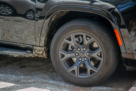 Close-up of a modern silver alloy wheel and Michelin tyre fitted to a white truck covered in fresh brown mud splatters. The detailed tyre sidewall and wheel show evidence of recent off-road drive