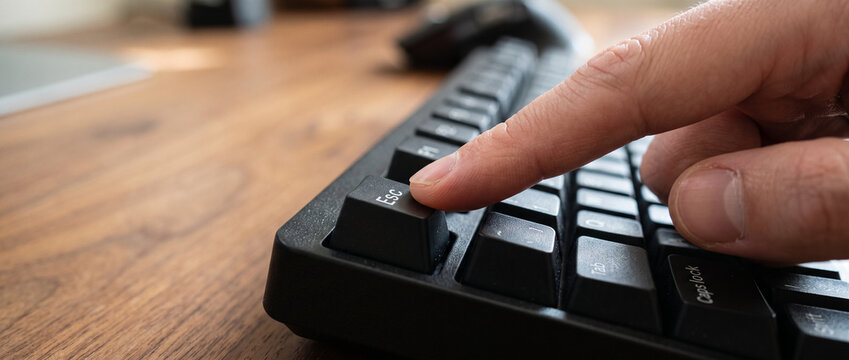Finger Pressing Esc Key on Computer Keyboard Close Up Technology Concept