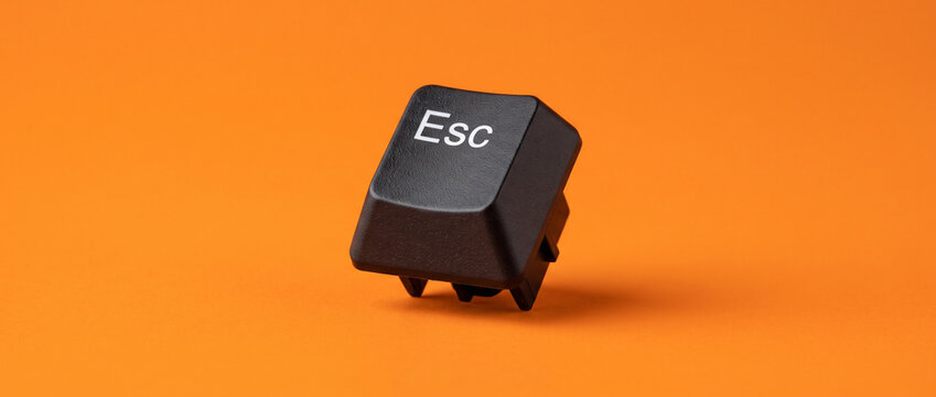 Black Esc Keyboard Key Isolated on Bright Orange Background