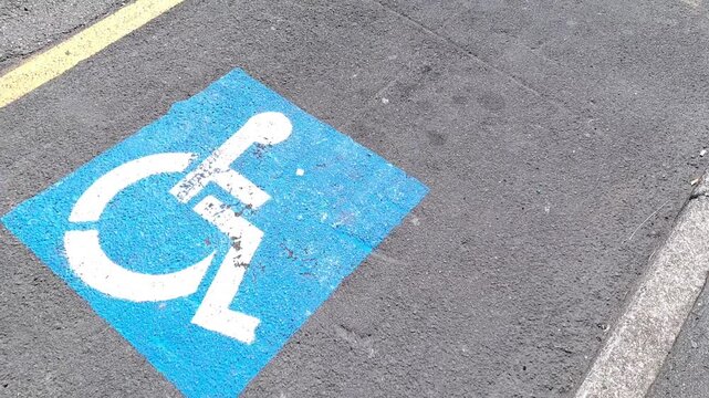 Wheelchair parking logo on the roadway, concept of accessible places for disabled people.