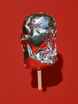 Metallic Balloon Ice Pop with Pointed Reflective Folds on Cherry Red Background