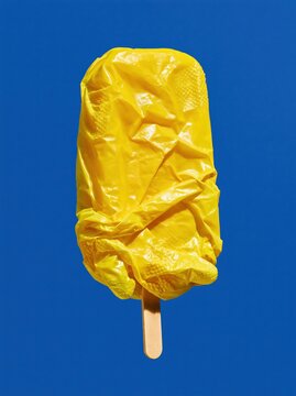Yellow Rubber Glove Ice Pop with Textured Folded Fingers on Cobalt Blue Background