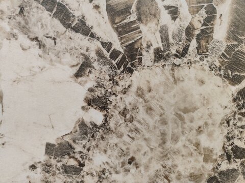 Close up view of breccia marble stone texture with large quartz fragments and dark mineral veins
