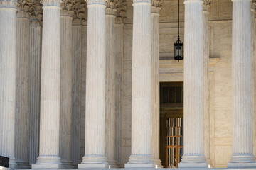 Fototapeta premium Supreme Court columns symbolize authority. Classical facade with massive pillars. Government building with timeless architecture. Court house exterior with elegant columns.