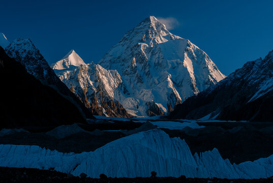 View of the majestic K2 mountain rising above the glacier with snow-capped peaks and dramatic shadows in the Karakoram Range, Gilgit Baltistan, Pakistan.