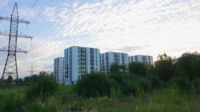 Modern residential apartment buildings in a green park area at sunset.