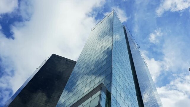 Modern glass skyscrapers and corporate office towers reflecting blue sky.
