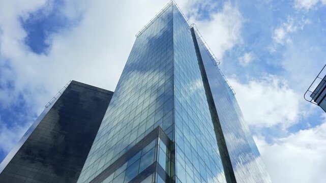 Modern glass skyscrapers and corporate office towers reflecting blue sky.
