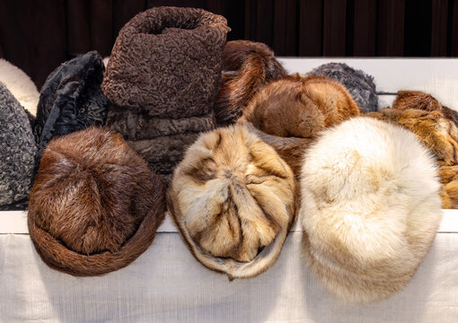 Pile of colorful fur winter hats sold outside on market stall