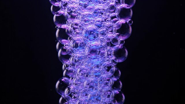 Abstract macro shot of purple bubbles rising against a black background.