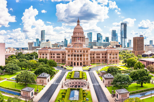 Texas State Capitol, the historic seat of government of Texas and one of the largest state capitol buildings in the United States, with Austin skyline in the background, on a sunny day.